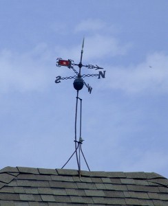 The weather vane on top of the house.